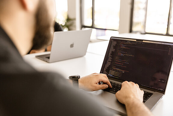 LightsOn Mitarbeiter benutzt Laptop und programmiert etwas