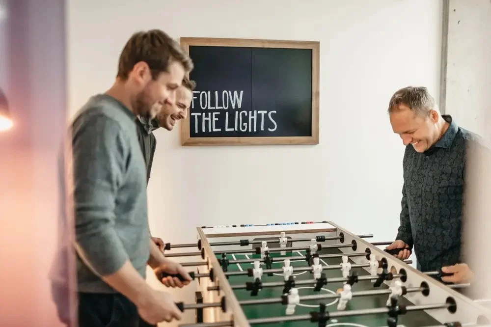 Drei Männer spielen Tischkicker