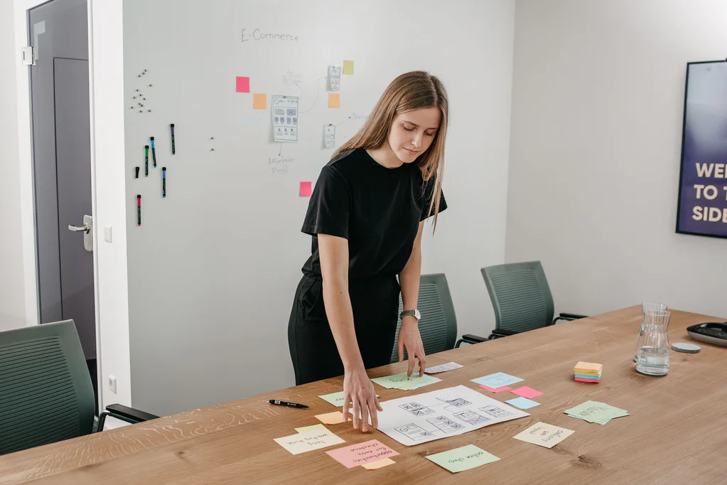 LightsOn Mitarbeiterin sortiert PostIts auf einem Tisch im Konferenzraum