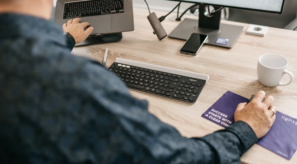 Blick über die Schulter mit Tastatur und Laptop
