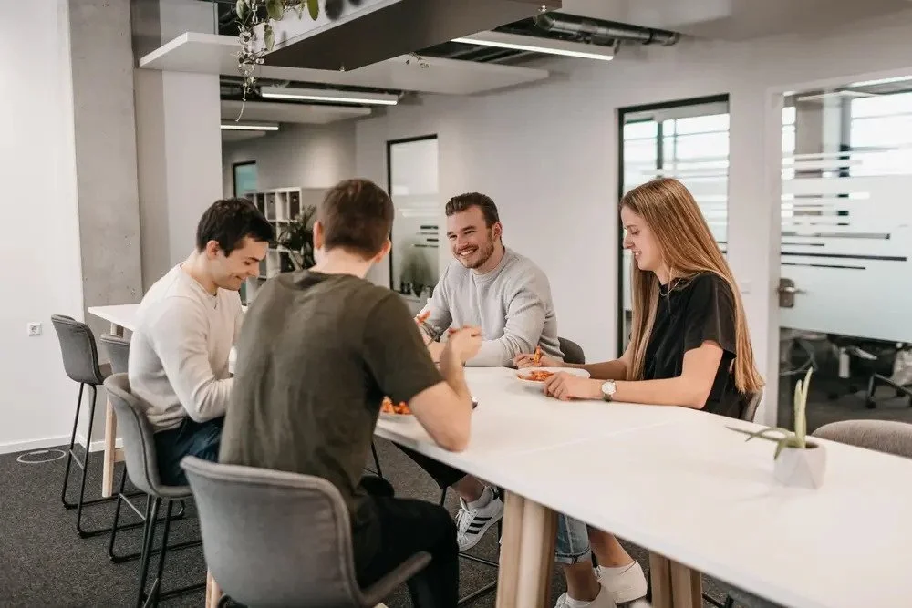 LightsOn Mitarbeiter sitzen zum Mittagessen gemeinsam am Tisch